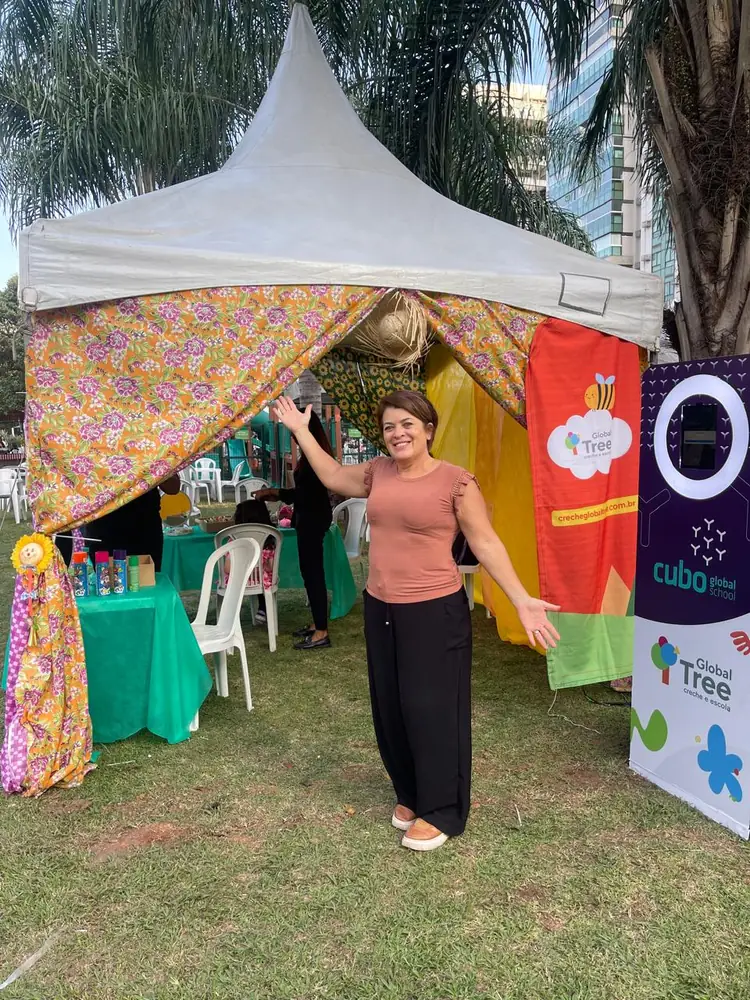 Colaboradora posando na entrada da tenda decorada