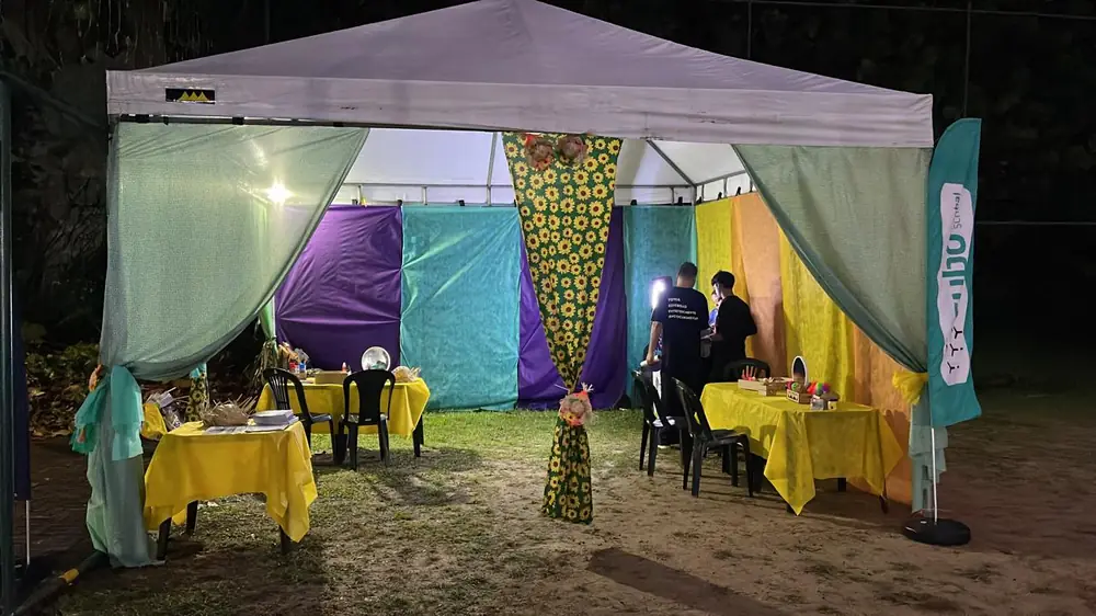 Tenda decorada com tecidos coloridos durante a noite